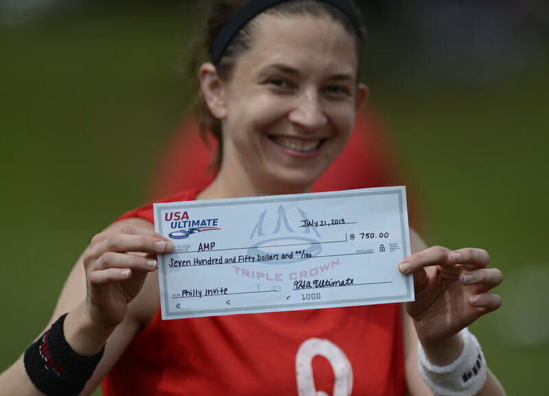 An AMP player shows off the team's prize money for winning the Mixed Pro-Elite Challenge.