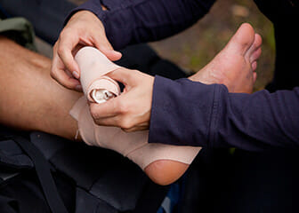An athletic trainer wraps an ankle.